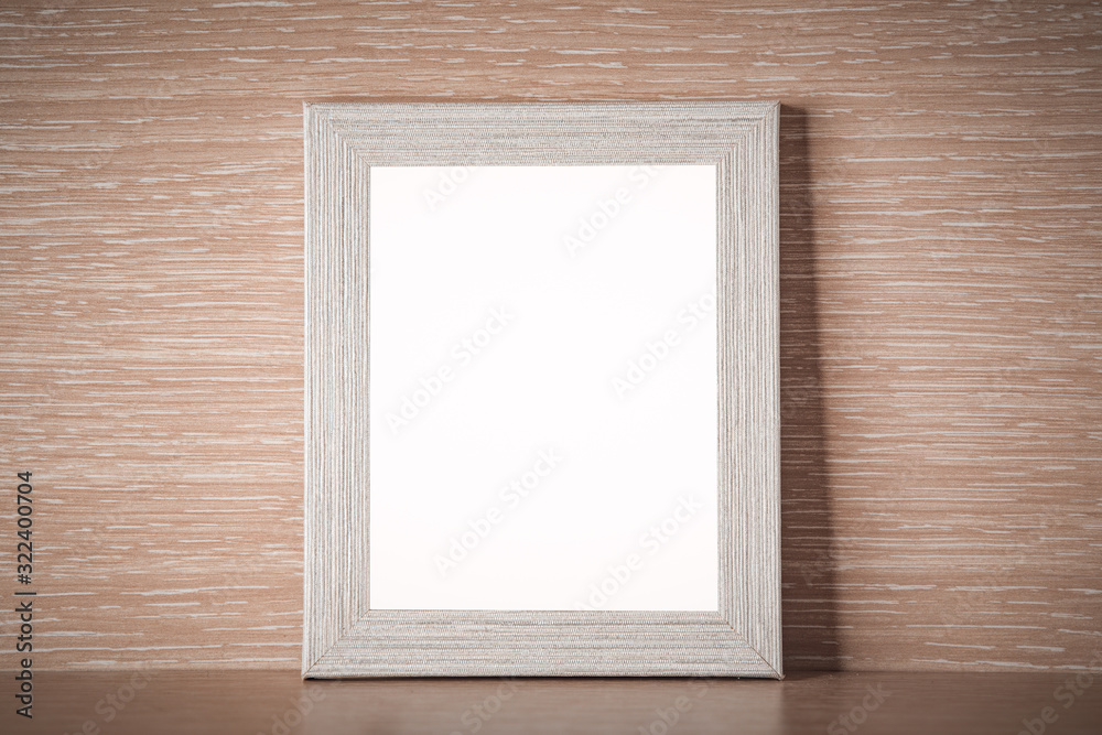 Light gray photo frame on a light wooden background, place for text Light gray photo frame on a light wooden background, place for text