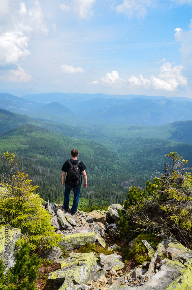 Man hiker standing on the background of mountains and forests. Carpathians, Gorgany ridge, Ukrainian landscape.