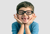 Very expresive toothless smile boy with hands on face and big eyeglasses