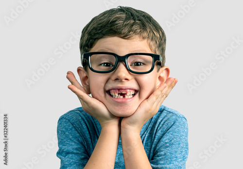 Fotografie, Obraz Very expresive toothless smile boy with hands on face and big eyeglasses