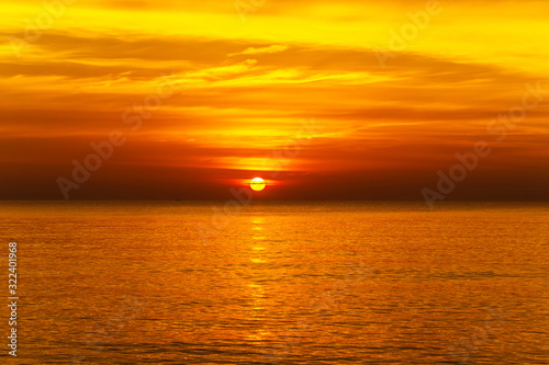 sunset with large yellow sun under the sea surface