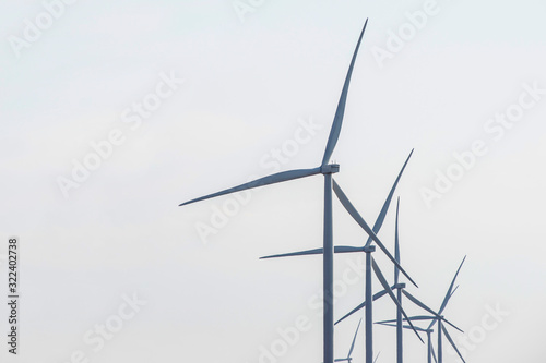 Wind farm. Wind Turbines in wind farm against sky. Energy conservation concept. Producing alternative energy © spyrakot