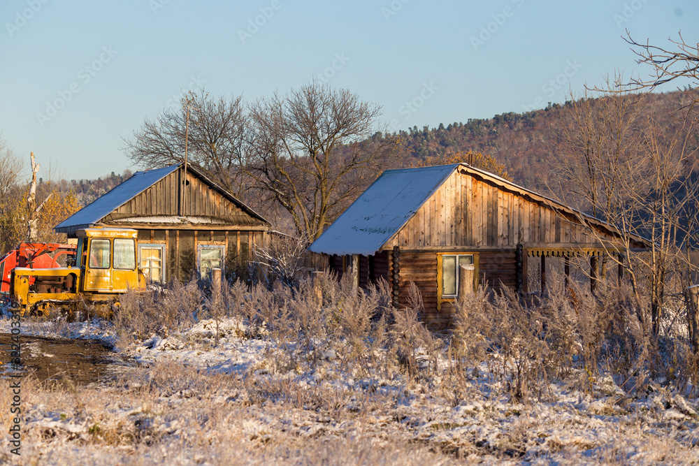 The village of Latin American Old Believers who returned to Russia in the Primorsky Territory. Wooden houses of Old Believers during a snowfall on a background of beautiful fields and mountains. The village of Latin American Old Believers who returned to Russia in the Primorsky Territory. Wooden houses of Old Believers during a snowfall on a background of beautiful fields and mountains.