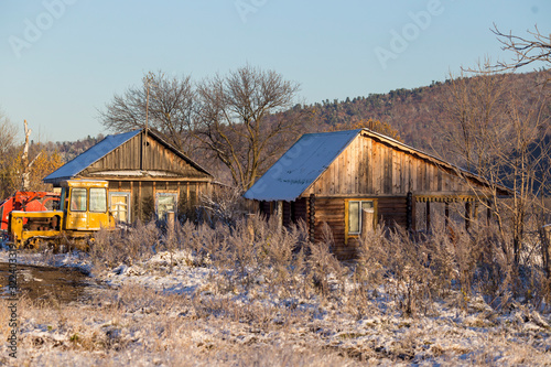 The village of Latin American Old Believers who returned to Russia in the Primorsky Territory. Wooden houses of Old Believers during a snowfall on a background of beautiful fields and mountains. © alexhitrov