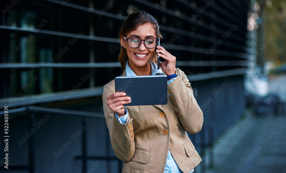 Fototapeta premium Good news about project. Young businesswoman in front of the corporation making a phone call. Business, education, lifestyle concept
