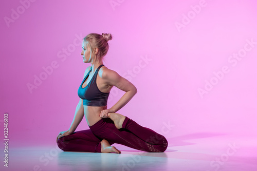 Yoga pose standing class. Slim fit blonde european girl involved in stretching sports. Work on yourself exercise fitness exercises for women. Asana relaxation harmony balance. Copy space neon trend