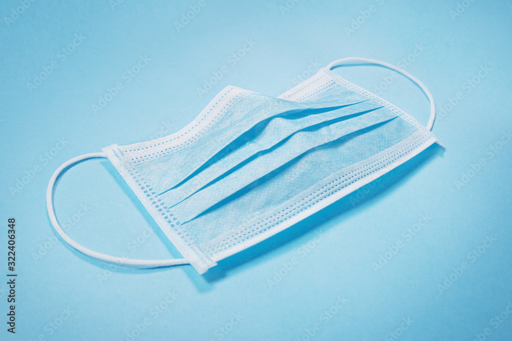 Surgical face mask laying on blue background Surgical face mask laying on blue background