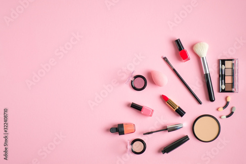 Professional makeup cosmetics set. Flat lay composition with lipstick, nail polish, make-up brush, nude eyeshadow palette on pastel pink background. Beauty salon banner design template