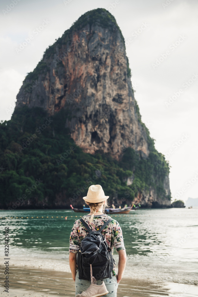 Woman looking at rock on the beach of Railay, Krabi, Thailand Woman looking at rock on the beach of Railay, Krabi, Thailand