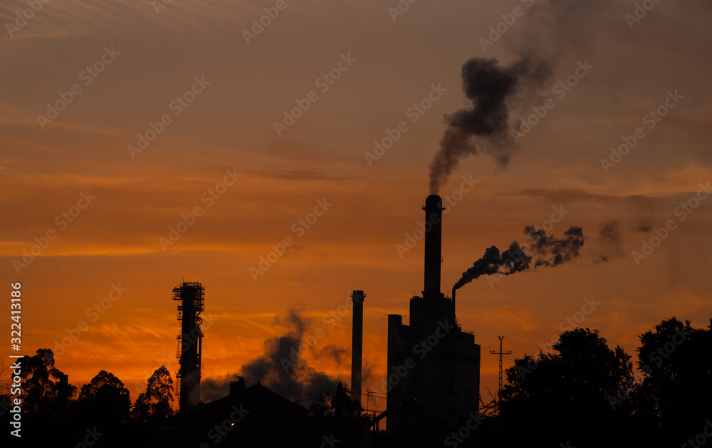 Smoke coming from the factory chimneys at sunset