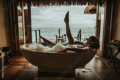 Woman relaxing in bathtub with view to the sea, Maguhdhuvaa Island, Gaafu Dhaalu Atoll, Maldives