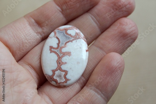 Crazy Lace Agate mineral (banded chalcedony, microcrystalline quartz) with red and brown frilly pattern, mined in Mexico. Oval shaped polished cabochon is ready for setting in jewellery. photo