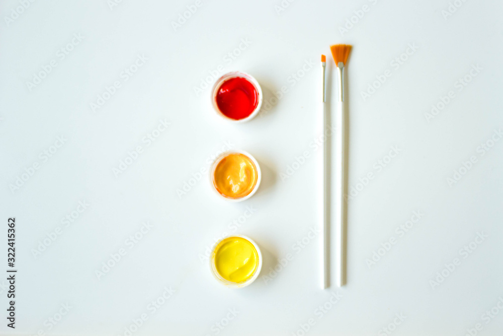 Paint art brushes on a white background with covers in red yellow and orange