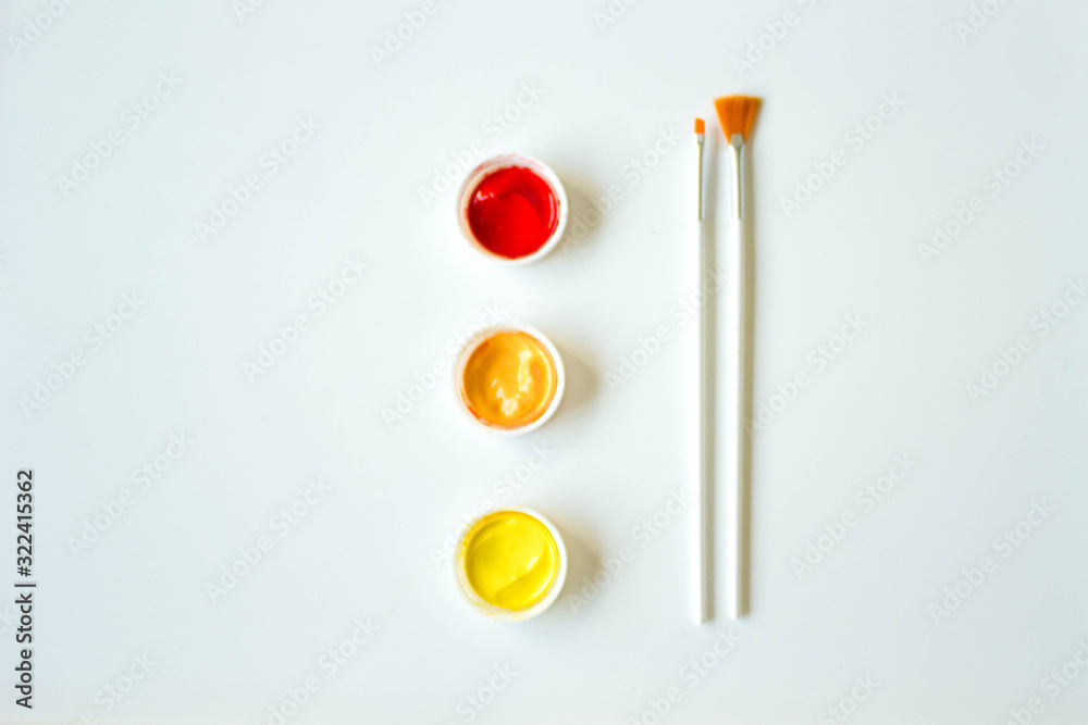 Paint art brushes on a white background with covers in red yellow and orange Paint art brushes on a white background with covers in red yellow and orange