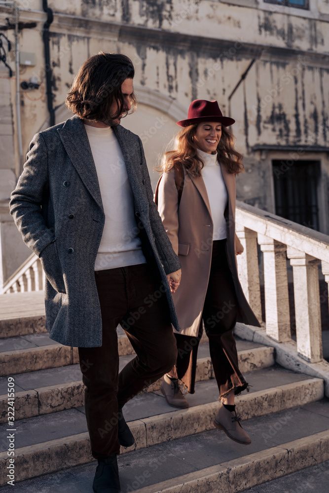 Young couple walking down a bridge in the city of Venice, Italy Young couple walking down a bridge in the city of Venice, Italy