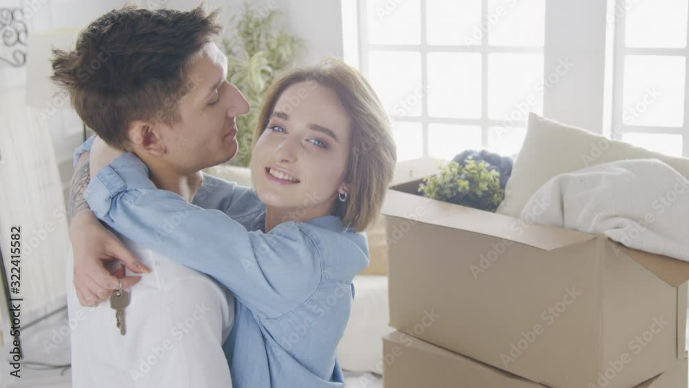 Young man and woman with carton boxes are entering room in new house. Young man and woman with carton boxes are entering room in new house.