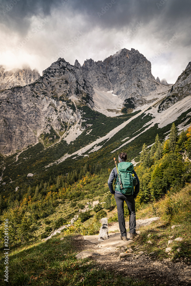 Woman on a hiking trip at Wilder Kaiser enjoying the view, Kaiser mountains, Tyrol, Austria Woman on a hiking trip at Wilder Kaiser enjoying the view, Kaiser mountains, Tyrol, Austria