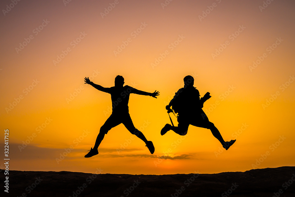 Silhouette man on sky background. Sport and active life,The Traveler jumping on top of the Mountain on sunset cloud sky.Victory concept. Silhouette man on sky background. Sport and active life,The Traveler jumping on top of the Mountain on sunset cloud sky.Victory concept.