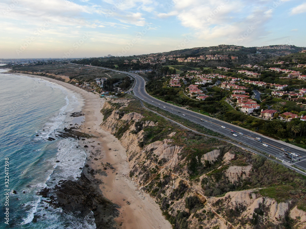 Aerial view of Newport Beach small road next to the cliff during sunset twilight in southern California, USA