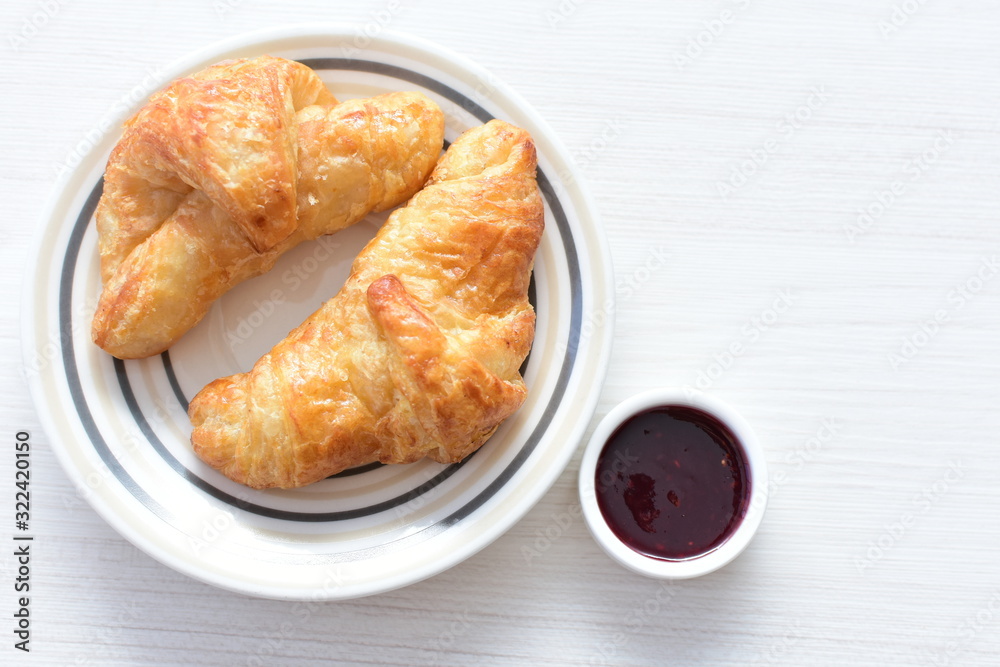 Small butter croissant, accompanied by blackberry jam