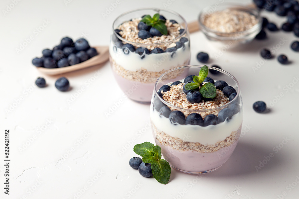 two blueberry yogurt in glasses on a white table, top view, ingredients for cooking diet food two blueberry yogurt in glasses on a white table, top view, ingredients for cooking diet food