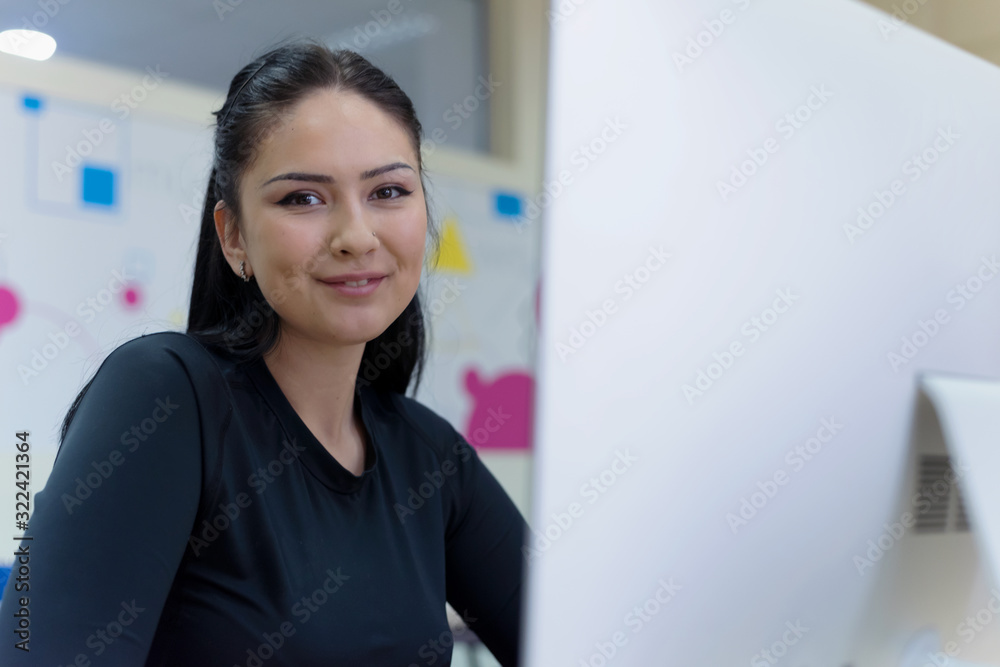 Beautiful female IT student working at her computer lab. Female studentsmoling and looking into camera. Education and technology concept. Beautiful female IT student working at her computer lab. Female studentsmoling and looking into camera. Education and technology concept.