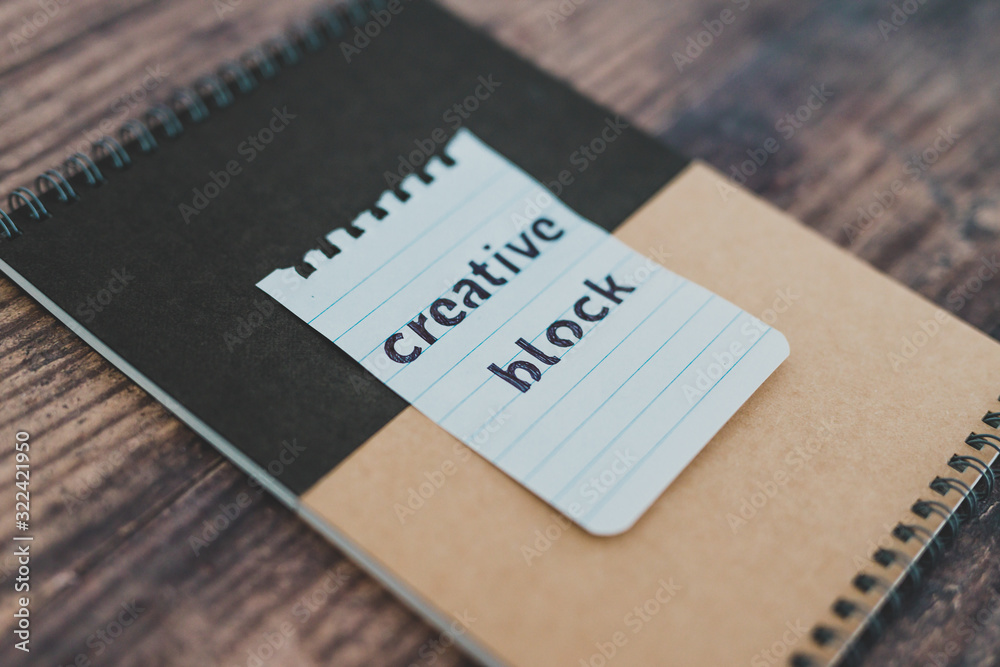 creative block or writer's block, notepads on wooden desk with text doodle on piece of paper creative block or writer's block, notepads on wooden desk with text doodle on piece of paper