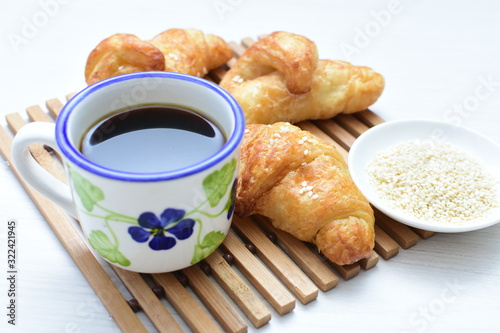 Small butter croissant, accompanied by coffee