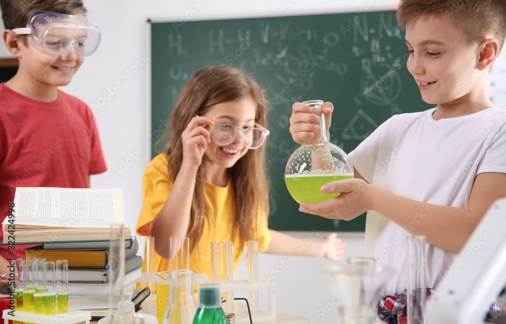 Smart pupils making experiment in chemistry class Smart pupils making experiment in chemistry class