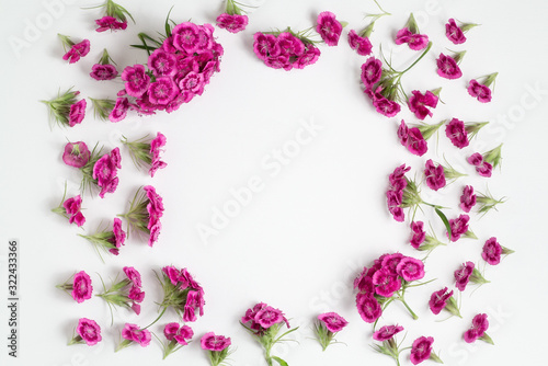 Fototapeta Naklejka Na Ścianę i Meble -  Floral arrangement with copy space. Template for greeting card or design. Frame of pink carnations on a white wooden background