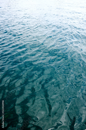 Ripples on water surface with reflections of sky and clouds. Simple minimal meditative marine landscape.