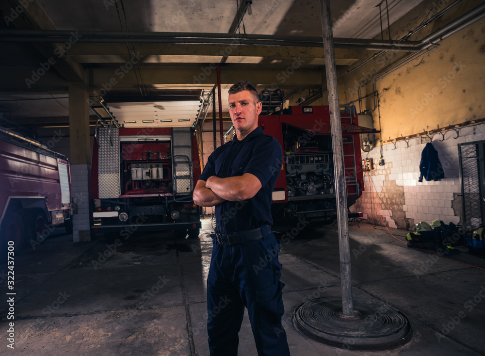Portrait of confident young fireman standing inside the fire departmant Portrait of confident young fireman standing inside the fire departmant