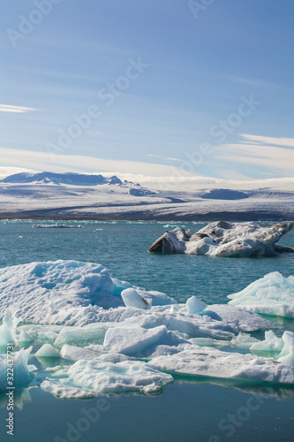 Icebergs and view of Jokuls  rl  n glacier lagoon in south Iceland  tourist popular natural attraction. Sunny summer day.