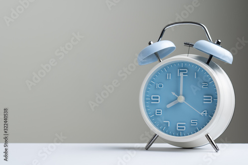 Blue color old fashioned bell alarm clock showing 8 o'clock isolated on white background photo