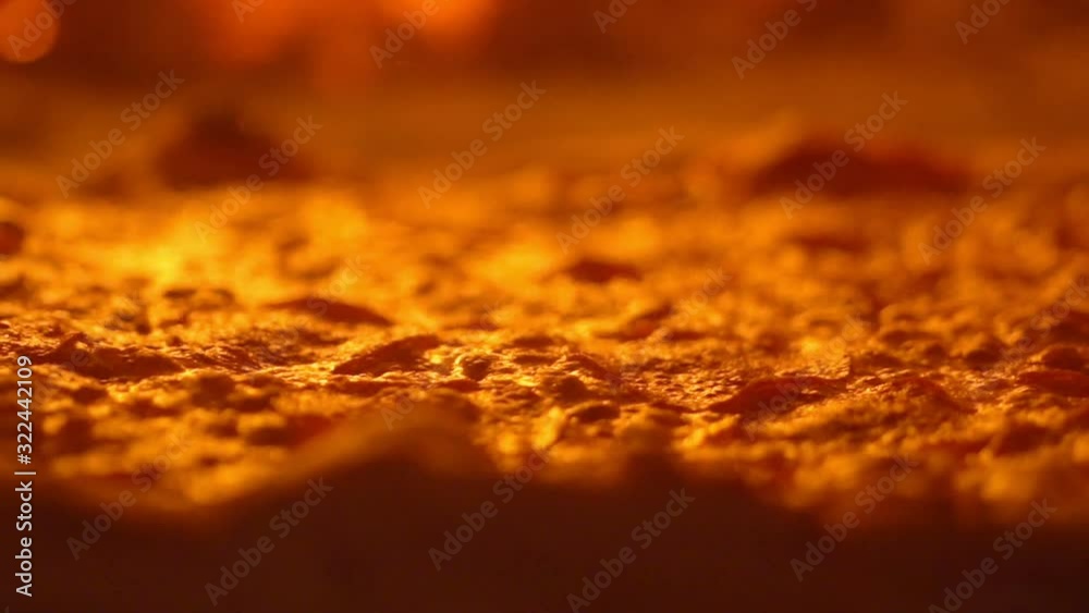 Lots of hot bubbling cheese on pizza. Fried crust and delicious salami in cheese. Pizza maker flips pizza with cooking spatula Lots of hot bubbling cheese on pizza. Fried crust and delicious salami in cheese. Pizza maker flips pizza with cooking spatula