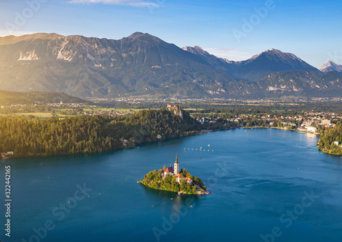 Scenic panoramic view of idyllic lake Bled with famous St. Marys Church on an island and historic old town with medieval castle and Karawank mountains in beautiful evening light at sunset, Slovenia photo