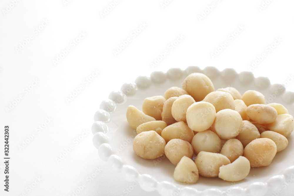 Roasted macadamia nuts on dish with copy space Roasted macadamia nuts on dish with copy space