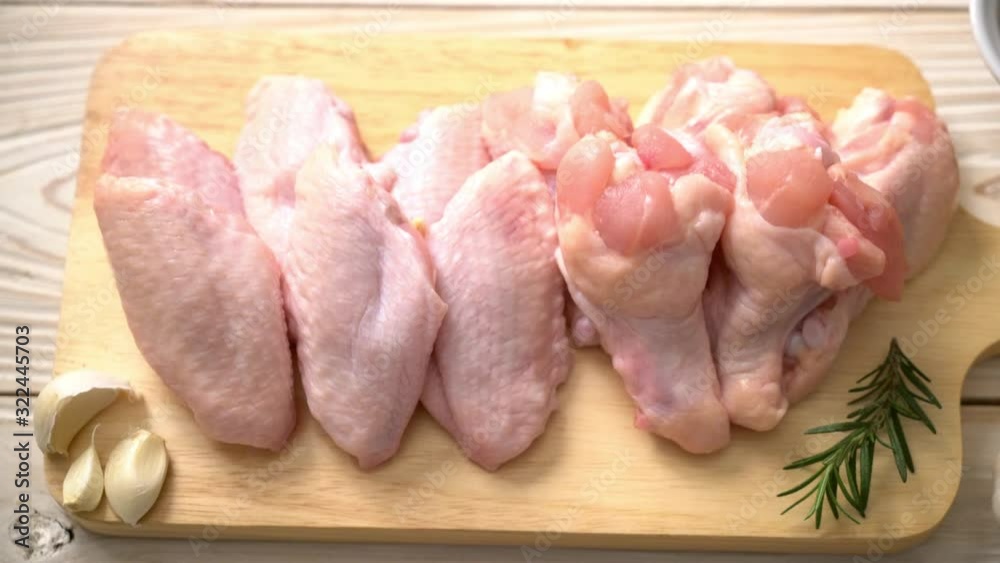 fresh raw chicken wings on wooden board with ingredients fresh raw chicken wings on wooden board with ingredients