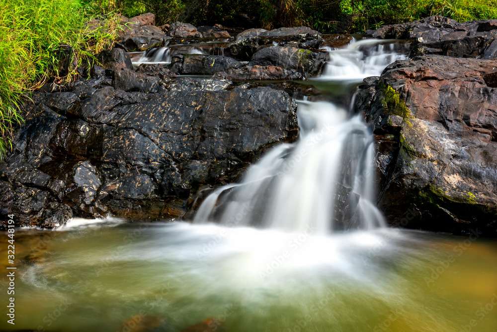 Magical stream in the rainforest with soft flowing water like wool flowing through the cliff creates a peaceful landscape to relax soul and music