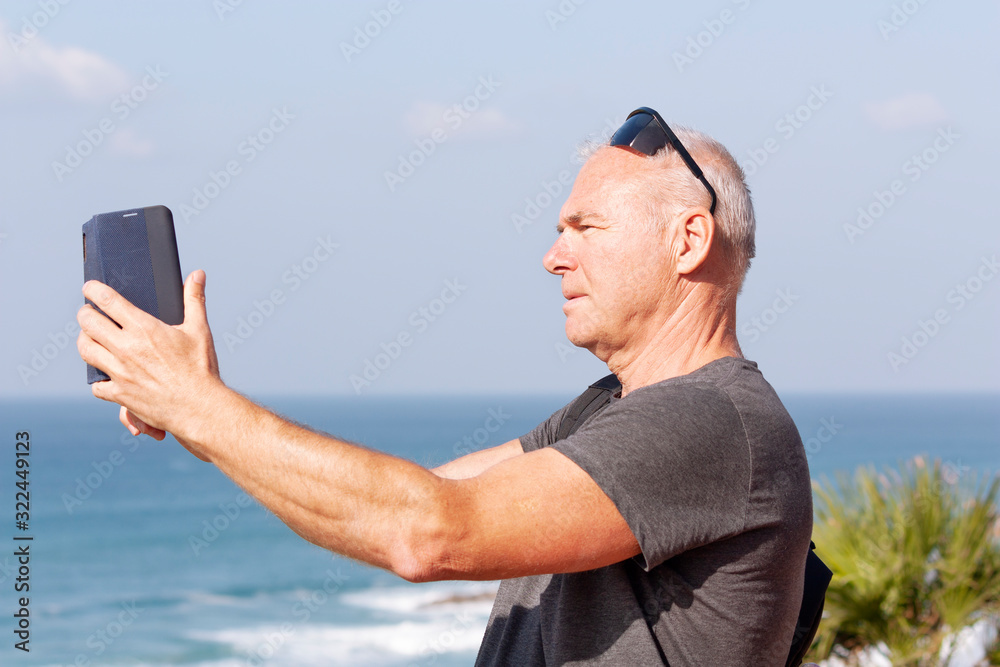 Tourist takes a selfie against the sea