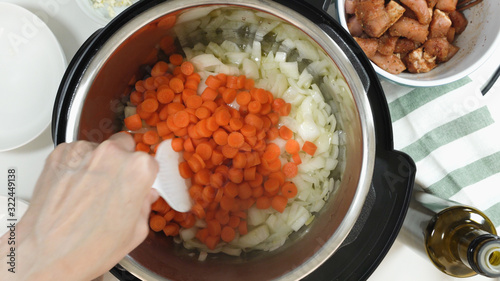 Canvas-taulu Saute chopped carrot and onion in a multicooker