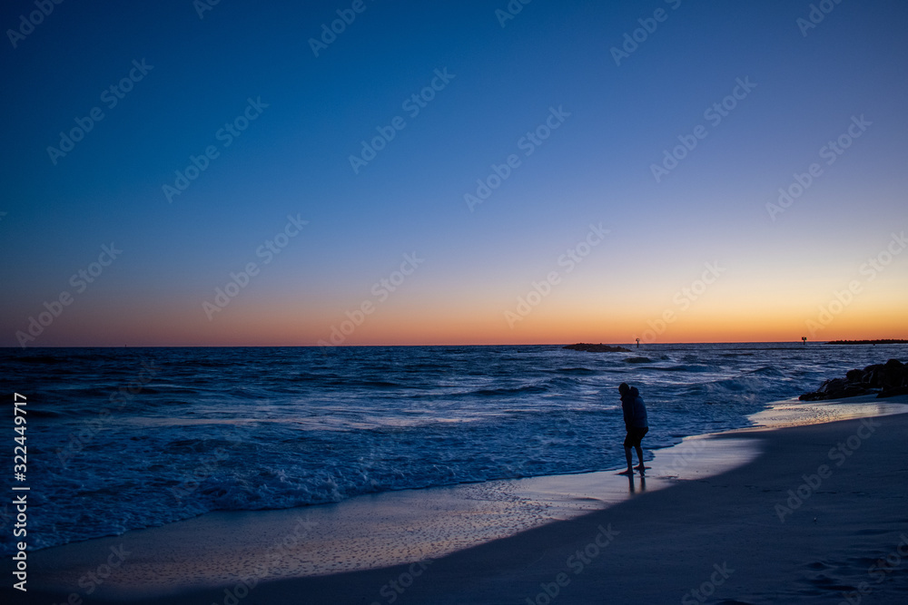 Man testing ocean waters sunrise sunset