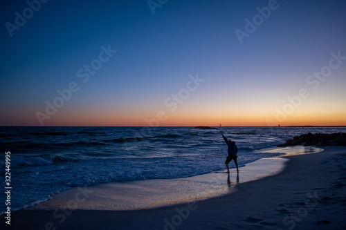 Man testing ocean waters sunrise sunset