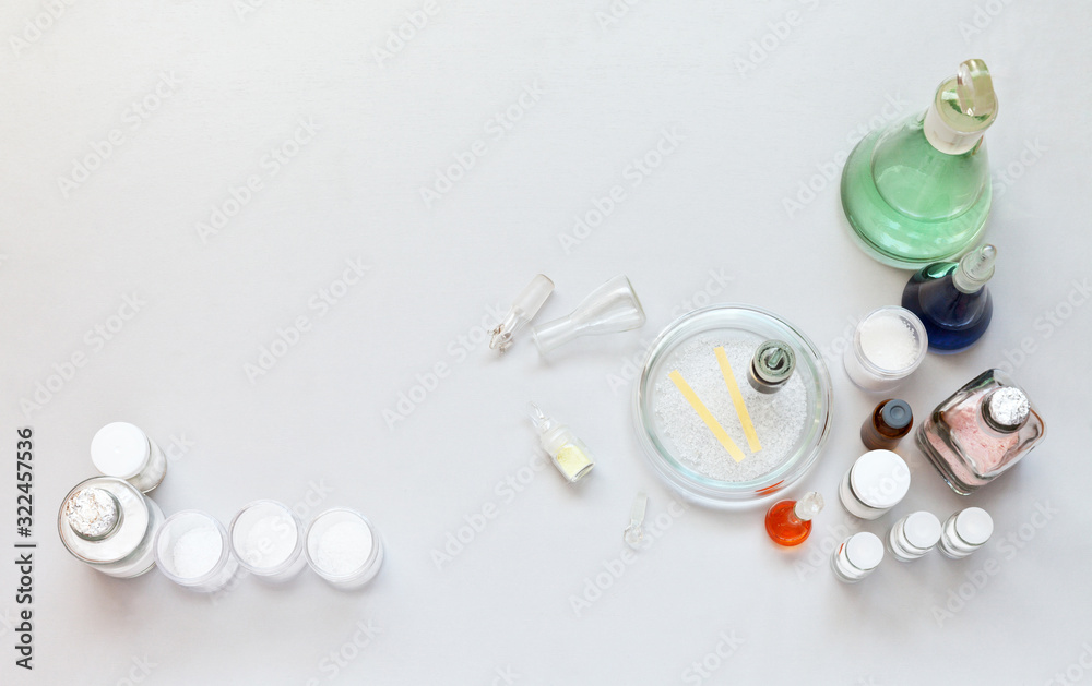 Top view on laboratory table with chemical glassware with color solutions in flasks, reagents in jars and Petri dish. The concept of chemical research. Flat lay, copy space, close-up, top view Top view on laboratory table with chemical glassware with color solutions in flasks, reagents in jars and Petri dish. The concept of chemical research. Flat lay, copy space, close-up, top view
