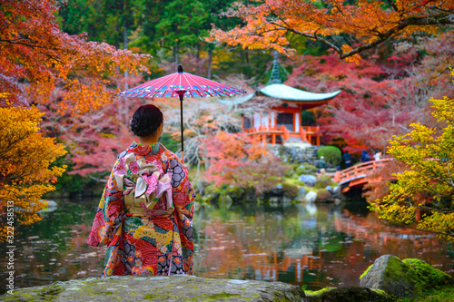 Canvas Print woman holding retro umbrella in old fashion style traditional kimono, sits in th