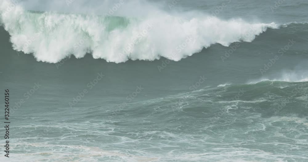 A huge wave forming on the rough seas of Nazare, Portugal - slow motion