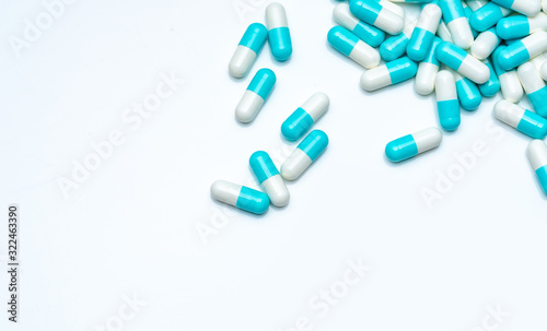 Blue-white capsule pills on white background. Antibiotic drug resistance concept. Capsule pills sampling in pharmaceutical industry. Antimicrobail medicine. Pharmacy product. Medication for infection.