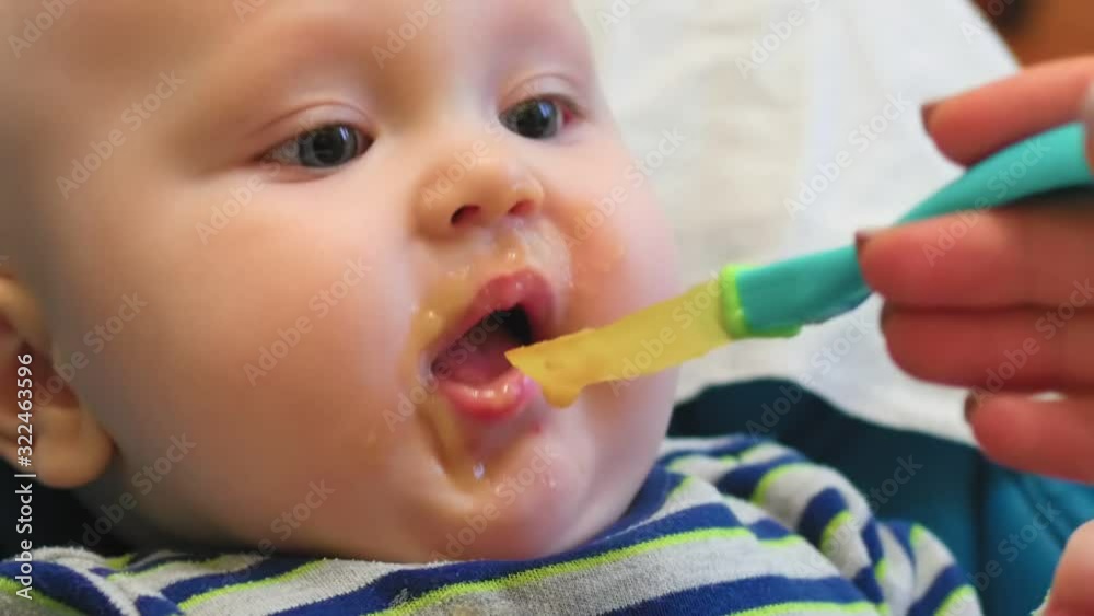 Mother feeding little baby with vegetable mash at home kitchen. Mother feeding little baby with vegetable mash at home kitchen.