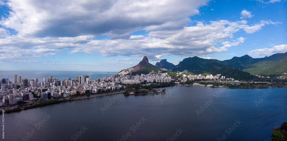 Aerial panorama of the city lake with  Two Brothers and Gavea mountain in the background against a blue sky with clouds