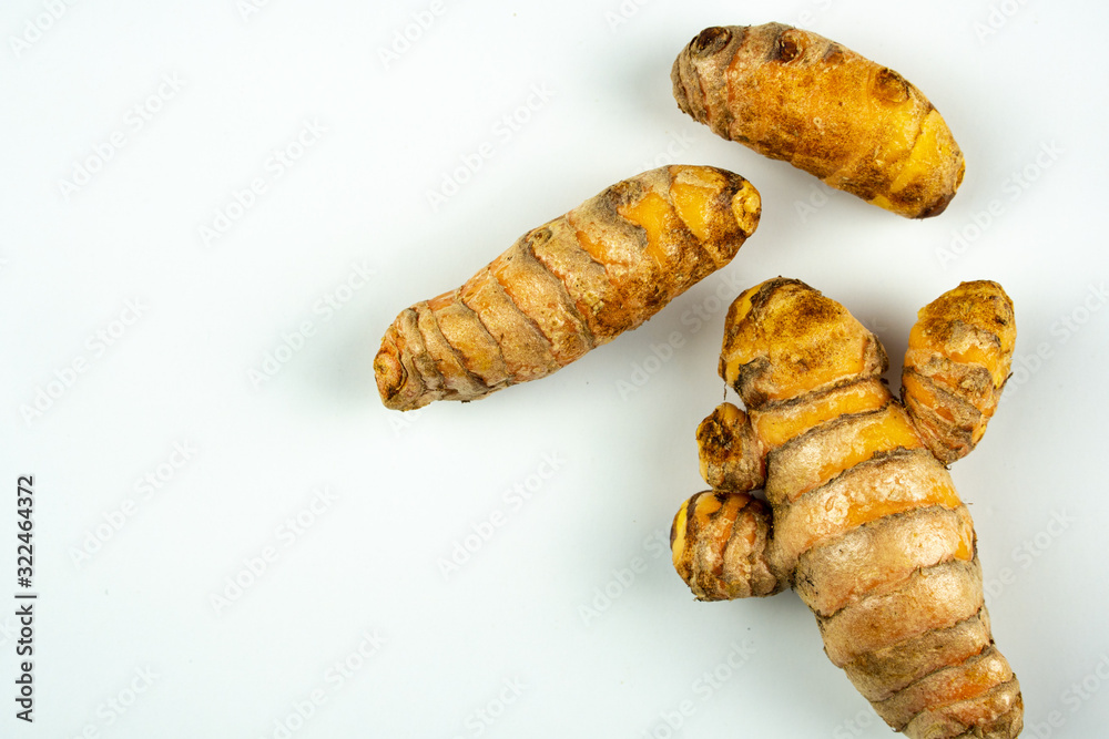 Raw fresh tumeric on white background with copyspace. Raw fresh tumeric on white background with copyspace.